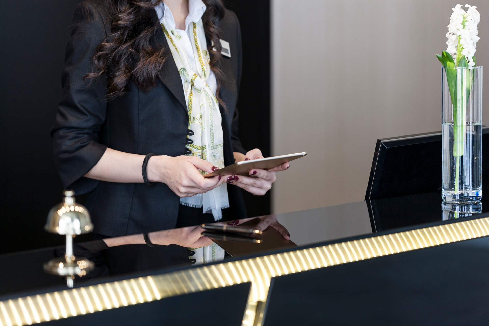 Hotel Receptionist checking up room status on digital tablet